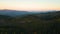 Aerial view of colorful evening over dark deforestated woods with cut down mountain forest trees at fall sunset