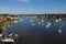 Aerial view of colorful sailboat moorings and docks surrounded by colorful residential rooftops on and azure blue Spa Creek, in hi