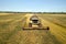 Aerial view of combine harvester harvesting large ripe wheat field. Agriculture from drone view