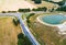 Aerial view of the confluence of two country roads next to a new development with a rain retention basin