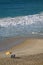 Aerial view of Copacabana beach with a pair of beach chairs and parasol hitting by the ocean waves