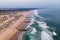 Aerial view of Costa da Caparica landscape at sunset, view of the majestic beach with rough Atlantic Ocean rolling on the