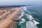 Aerial view of Costa da Caparica landscape at sunset, view of the majestic beach with rough Atlantic Ocean rolling on the