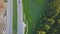 Aerial view at the country highway passing near forest in evergreen northern forests. Clip. Top view of the motorway
