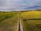 Aerial view of a country road in the middle of a vast agricultural field