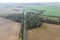 Aerial view of country road passing through the agricultural fields at foggy autumn morning