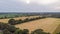 An aerial view of countryside panorama with fields, trees,forest and rural road under a stromy sky and shady sun