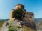 Aerial view of couple tourists at Jvari clifftop orthodox monastery located in Mtskheta Georgia. Summer day time. Travel and