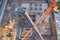 Aerial view, crane truck at the construction site works the installation of the boom of a tower crane, against the background of