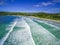 Aerial view of crushing ocean waves and white sandy beach.