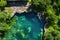 aerial view of a crystal clear natural pool surrounded by lush greenery