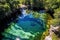 aerial view of a crystal clear natural pool surrounded by lush greenery