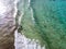 Aerial view of a crystal clear sea with waves and surfers. Playa De La Canteria. Orzola, Lanzarote, Canary Islands. Spain