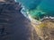 Aerial view of a crystal clear sea with waves and surfers. Playa De La Canteria. Orzola, Lanzarote, Canary Islands. Spain