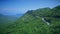 Aerial view of a curved winding road with cars passing. Mountain road