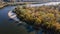 Aerial view of the curving river near forest during autumn time