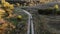 Aerial view cyclist racing along dirt road at sunset