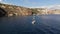 Aerial view Daytime panoramic scenic view of drifting sailing yacht on water, bay surrounded by mountains. Panning