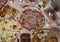 Aerial view of delicious varieties of freshly prepared Neapolitan Mediterranean pizzas and tapas on wooden table