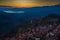 Aerial view of Delphi, Greece, the Gulf of Corinth, orange color of clouds, mountainside with layered hills beyond with