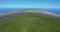 Aerial view dense pine tree forest on Tenerife with a glimpse of distant coastal city.