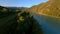 Aerial view dense tree tops at early morning sunlight natural valley with path river and mountain