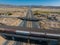 Aerial View of Desert Highway Interchange with Train Tracks and Rugged Mountains