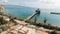 Aerial view of destroyed buildings and a long pier by the sea. Shot. Abandoned old town area located by the calm sea