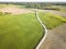 Aerial View of Dirt Road Separating Green Meadow and Brown Agricultural Field