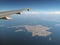 Aerial view of the dodecanese greek islands of kalymnos and telendos from an airplane with wing visible with blue sky and clouds o