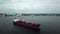 Aerial view from drone of international cargo ship at industrial import-export port sailing to transport goods around