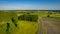 Aerial view with a drone of a spring wavy agricultural countryside landscape with plowed and unplowed fields and trees