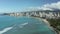 Aerial view from drone with static shot from coast of Waikiki looking towards Honolulu on Oahu