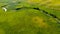 Aerial view from the drone of summer landscape with river, hills and forests. Cows graze in the meadow