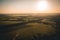 Aerial view from drone to summer rural landscape at sunset sunlight with fields and trees