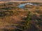 Aerial view of a dry sandy landscape with a small lake and winding road in Extremadura, Spain