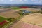 Aerial view of Dutch agricultural landscape with green fields, tulip fields in distance