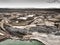 Aerial view of the edge of a large white sand quartz quarry.