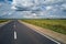 Aerial view of empty intercity road between green agricultural fields. Top view from drone of highway roadway