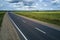 Aerial view of empty intercity road between green agricultural fields. Top view from drone of highway roadway