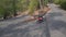 Aerial view of enduro motorcycles driving on rural road through green forest and mountain