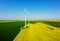 Aerial view of eolian turbines. Rapeseed field in bloom. Renewable energy