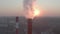 Aerial view of evening sun behind industrial smoke stack