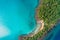 Aerial view of exotic turquoise sea with white beach green tree island