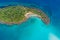 Aerial view of exotic turquoise sea with white beach green tree island