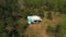 An aerial view of a family holiday near a motorhome in the woods . Travel concept