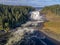 Aerial view famous waterfall Tannforsen northern Sweden, with a rainbow in the mist and rapid flowing cascades of water