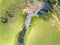 Aerial view of Farm field, trees and stream with waterfall