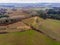 Aerial view on a farm fields with a trees, small creek and a pond.