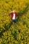 Aerial view of farmer examining blooming rapeseed field
